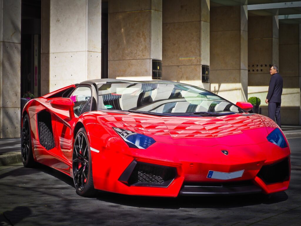 A striking red Lamborghini Huracán parked in front of a luxury building, exuding elegance and performance
