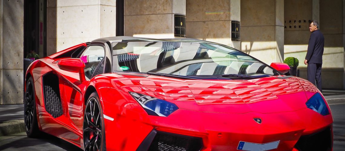 A striking red Lamborghini Huracán parked in front of a luxury building, exuding elegance and performance